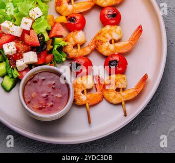 Brochettes de crevettes gourmandes avec salade verte et sauce Banque D'Images