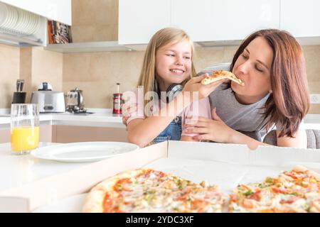 Concept de famille, mère et fille mangeant une pizza savoureuse Banque D'Images