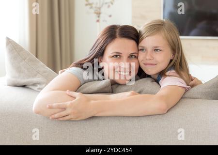 Mère et fille Pré-ado assis sur la table en souriant. Concept de famille heureuse Banque D'Images