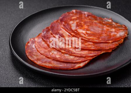 Délicieuse viande fumée tranchée avec du sel, des épices et des herbes Banque D'Images