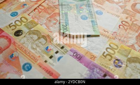 Les billets de banque philippins de différentes coupures telles que 500, 200, 100 et 20 pesos sont étalés, mettant en évidence la monnaie vibrante des philippines Banque D'Images