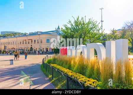 Kiev, Ukraine - 9 octobre 2024 : scène animée mettant en vedette le panneau I Love Podil avec des gens et des bâtiments historiques en arrière-plan, mettant en évidence celle de Kiev Banque D'Images