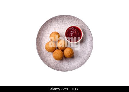 Boules de frites avec brie pané ou camembert avec sauce aux baies sucrées sur fond blanc Banque D'Images