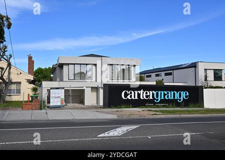 Le chantier de construction de la maison de ville carter Grange, avec une palissade et une clôture bloquant l'accès au chantier, vu de l'autre côté de la route pendant la journée Banque D'Images