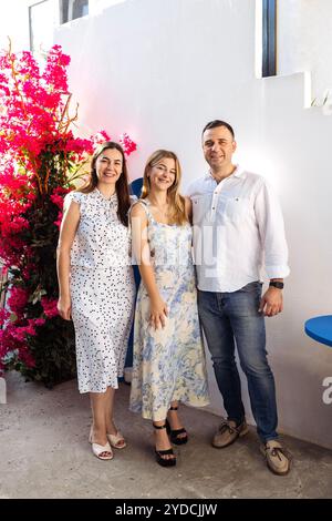 Une adolescente mignonne et ses parents dans des vêtements de fantaisie sourient et posent. Une jeune fille joyeuse, son père et sa mère s'embrassent lors d'une réunion festive. Un homme et une femme wi Banque D'Images