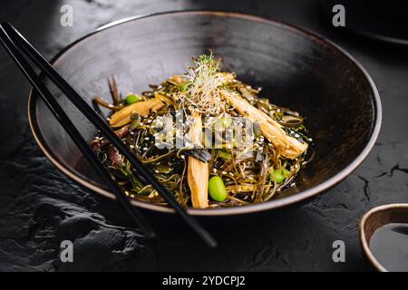 Plat épicé, nouilles avec viande et légumes dans un wok poêle Banque D'Images