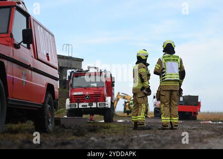 26 octobre 2024, basse-Saxe, Meppen : de nombreux membres du personnel d'urgence et des véhicules se sont rassemblés dans la lande pour un exercice à grande échelle par les pompiers des forces armées allemandes de Meppen avec les pompiers voisins. Avec douze pompiers voisins ainsi que des forces de l'organisation locale de secours technique et de la Croix-Rouge allemande, la brigade de pompiers des forces armées allemandes Meppen mène un exercice majeur sur le terrain de la Wehrtechnische Dienststelle für Waffen und munition (WTD 91) à Meppen. Le but de l'exercice est de former plus de 300 participants, y compris Banque D'Images