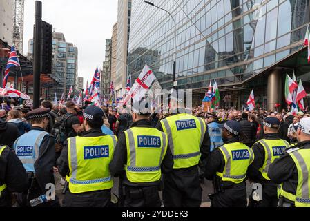 Westminster, Londres, Royaume-Uni. 26 octobre 2024. Les partisans de Stephen Yaxley-Lennon (alias Tommy Robinson) se rassemblent dans Victoria Street pour une marche de protestation vers Whitehall. Les thèmes de la manifestation incluent l'immigration, et une manifestation d'opposition organisée par Stand Up to Racism est prévue pour marcher à l'autre bout de Whitehall. La police métropolitaine et les unités recrutées d'ailleurs participent en nombre à la lutte contre la violence. Cordon de police retenant les manifestants dans la rue Victoria Banque D'Images