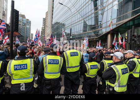 Westminster, Londres, Royaume-Uni. 26 octobre 2024. Les partisans de Stephen Yaxley-Lennon (alias Tommy Robinson) se rassemblent dans Victoria Street pour une marche de protestation vers Whitehall. Les thèmes de la manifestation incluent l'immigration, et une manifestation d'opposition organisée par Stand Up to Racism est prévue pour marcher à l'autre bout de Whitehall. La police métropolitaine et les unités recrutées d'ailleurs participent en nombre à la lutte contre la violence. Cordon de police retenant les manifestants dans la rue Victoria Banque D'Images