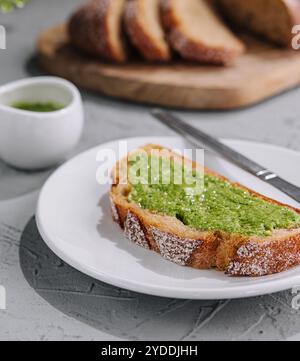 Pain avec sauce pesto maison tartinée avec un couteau Banque D'Images