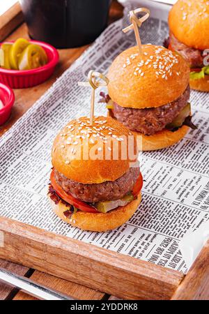 Mini hamburgers en gros plan sur plateau en bois Banque D'Images