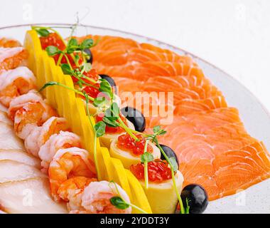 Saumon, poisson blanc, crevettes et caviar rouge sur assiette Banque D'Images