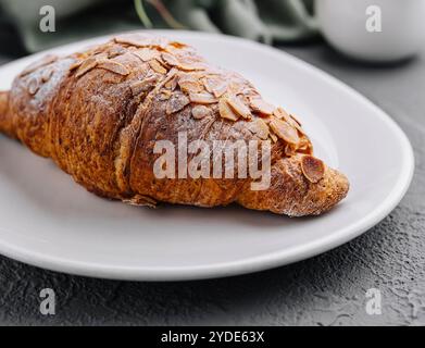 Croissant aux amandes sur l'assiette gros plan Banque D'Images