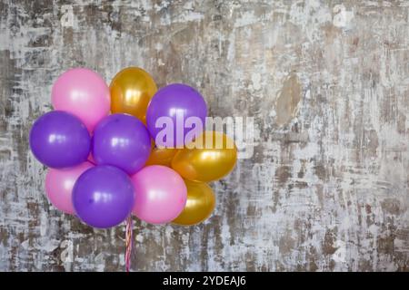 Bouquet de ballons lumineux contre un mur texturé Banque D'Images