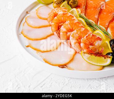 Saumon, poisson blanc, crevettes et olives sur assiette Banque D'Images