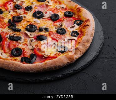 Pizza avec tomate, olives, champignons, jambon et fromage Banque D'Images
