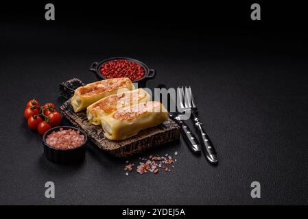 Crêpe sucrée ou salée avec différentes garnitures pour un petit déjeuner copieux sur un fond de béton foncé Banque D'Images