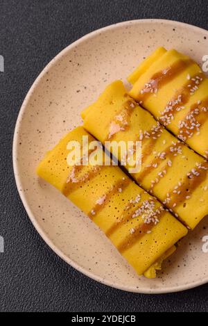 Crêpe sucrée ou salée avec différentes garnitures pour un petit déjeuner copieux sur un fond de béton foncé Banque D'Images