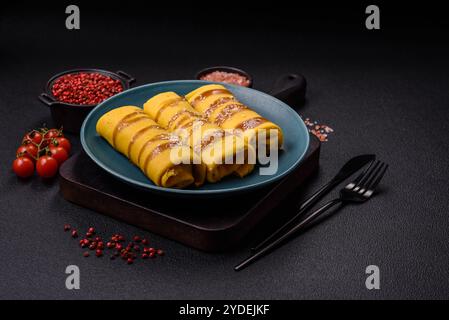 Crêpe sucrée ou salée avec différentes garnitures pour un petit déjeuner copieux sur un fond de béton foncé Banque D'Images