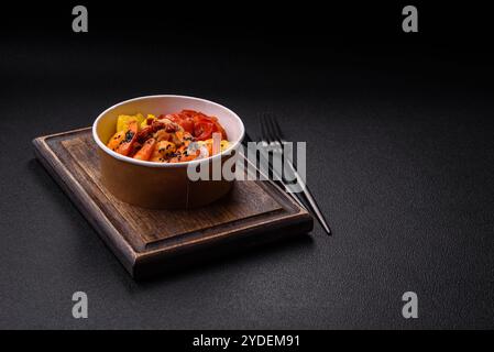 Crevettes tigrées bouillies avec du porridge, des tomates et du maïs sur un fond de béton foncé Banque D'Images