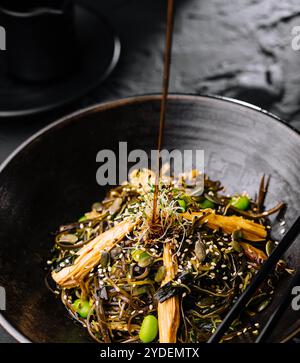 Plat épicé, nouilles avec viande et légumes dans un wok poêle Banque D'Images