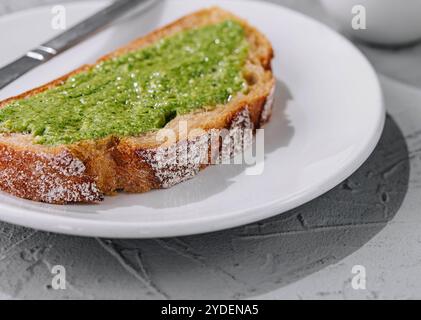 Pain avec sauce pesto maison tartinée avec un couteau Banque D'Images