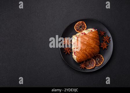 Croissant rouge sucré croustillant à la pistache, à la framboise et à la fraise sur un fond de béton foncé Banque D'Images