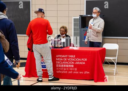 Brooklyn, NY, États-Unis. 26 octobre 2024. Le premier jour du vote par anticipation dans l'État de New York, quelques personnes sont arrivées 40 minutes avant l'ouverture des bureaux de vote à 8 heures à l'Edward R. Murrow High School de Midwood pour s'assurer qu'elles avaient une place dans la file d'attente. Les électeurs qui n'ont pas été trouvés dans le rôle d'électeur actif, ou qui ont demandé des bulletins de vote absents, peuvent obtenir un bulletin de vote par affidavit qui est compté seulement si leurs renseignements peuvent être vérifiés, ou dans le cas des bulletins de vote absents, si leurs bulletins de vote absents n'ont pas été reçus. Crédit : Ed Lefkowicz/Alamy Live News Banque D'Images