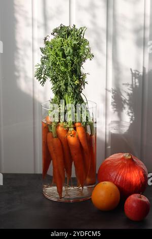 Bouquet de carottes biologiques fraîches dans un vase en verre. Concept d'alimentation saine. Bouquet fait de carottes. Banque D'Images