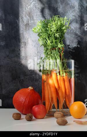 Bouquet de carottes biologiques fraîches dans un vase en verre. Concept d'alimentation saine. Bouquet fait de carottes. Banque D'Images