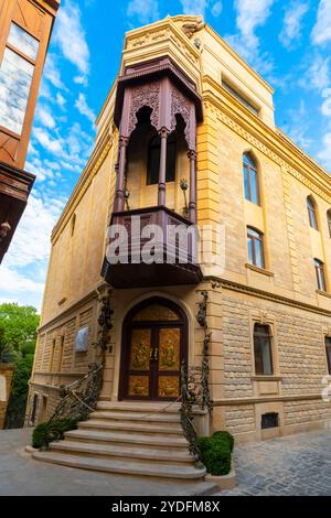 Un bâtiment traditionnel azerbaïdjanais avec balcon en bois orné près de Qüllə Kü (rue Qülla), quartier Icheri Sheher, Bakou, vieille ville, Azerbaïdjan. Banque D'Images