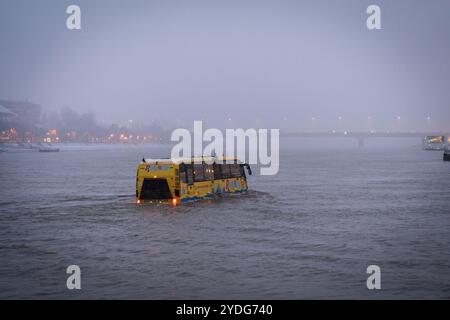 Budapest, Hongrie - 23 décembre 2023 : bus amphibie flottant sur le Danube avec le pont Árpád en arrière-plan Banque D'Images