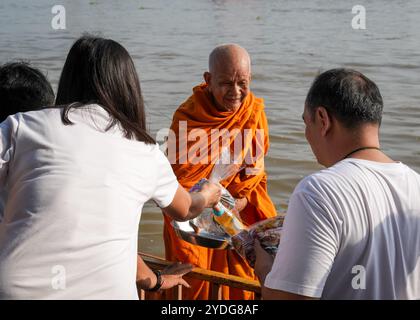 Thaïlande. 25 octobre 2024. Gros plan d'un moine souriant recevant des offrandes de gens, sur la rive de la rivière Chao Phraya, au temple Wat Chin Wararam Worawihan. La tradition de donner l'aumône à une centaine de moines à Pathum Thani, en Thaïlande, est une cérémonie bouddhiste vieille de plusieurs siècles qui se tient le long des rivières et des canaux après la fin du Carême bouddhiste. Les moines se rassemblent dans des bateaux pour recevoir des offrandes des habitants, qui préparent la nourriture et participent à la création de mérite. Cet événement célèbre la communauté, la foi et le patrimoine culturel. Crédit : SOPA images Limited/Alamy Live News Banque D'Images