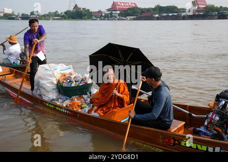 Thaïlande. 25 octobre 2024. Un moine est vu assis sur une barque avec un parapluie, et des paniers d'offrandes, sur la rivière Chao Phraya. La tradition de donner l'aumône à une centaine de moines à Pathum Thani, en Thaïlande, est une cérémonie bouddhiste vieille de plusieurs siècles qui se tient le long des rivières et des canaux après la fin du Carême bouddhiste. Les moines se rassemblent dans des bateaux pour recevoir des offrandes des habitants, qui préparent la nourriture et participent à la création de mérite. Cet événement célèbre la communauté, la foi et le patrimoine culturel. Crédit : SOPA images Limited/Alamy Live News Banque D'Images