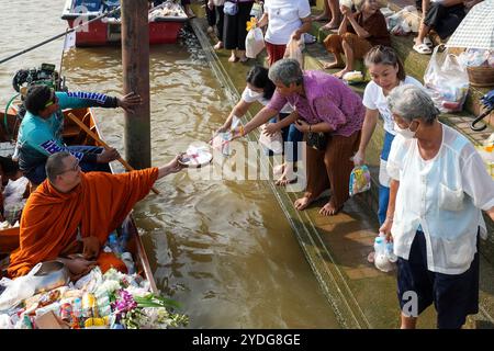 Thaïlande. 25 octobre 2024. Un moine assis dans une barque est vu la main tendue pour recevoir des offrandes du peuple thaïlandais, sur la rive de la rivière Chao Phraya au temple Wat Chin Wararam Worawihan. La tradition de donner l'aumône à une centaine de moines à Pathum Thani, en Thaïlande, est une cérémonie bouddhiste vieille de plusieurs siècles qui se tient le long des rivières et des canaux après la fin du Carême bouddhiste. Les moines se rassemblent dans des bateaux pour recevoir des offrandes des habitants, qui préparent la nourriture et participent à la création de mérite. Cet événement célèbre la communauté, la foi et le patrimoine culturel. Crédit : SOPA images Limited/Alamy Live News Banque D'Images