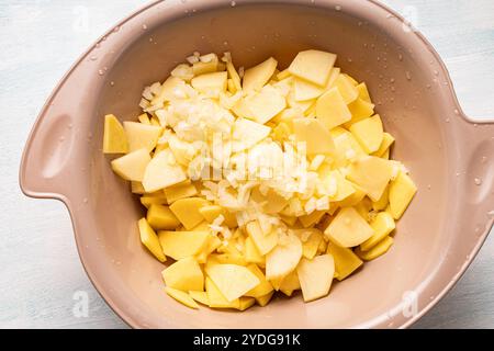 Pommes de terre hachées crues et oignons finement hachés dans un bol. Vue de dessus, gros plan. Photo de haute qualité Banque D'Images