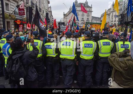 Londres, Royaume-Uni. 26 octobre 2024. Les policiers forment un cordon alors que les militants d’Antifa participent à la marche à Piccadilly Circus contre le racisme, le fascisme et l’extrême droite, tandis que les manifestants d’extrême droite organisaient leur propre marche et se rassemblaient pour soutenir la figure d’extrême droite récemment arrêtée Tommy Robinson. Crédit : Vuk Valcic/Alamy Live News Banque D'Images