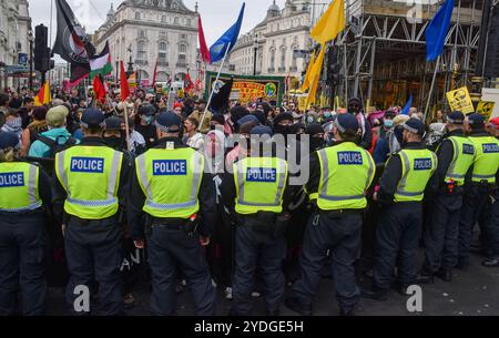 Londres, Royaume-Uni. 26 octobre 2024. Les policiers forment un cordon alors que les militants d’Antifa participent à la marche à Piccadilly Circus contre le racisme, le fascisme et l’extrême droite, tandis que les manifestants d’extrême droite organisaient leur propre marche et se rassemblaient pour soutenir la figure d’extrême droite récemment arrêtée Tommy Robinson. Crédit : Vuk Valcic/Alamy Live News Banque D'Images