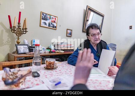 Tbilissi, Géorgie. 26 octobre 2024. Les fonctionnaires électoraux conversent avec une femme âgée dans sa résidence, s'assurant qu'elle est à l'aise et informée du processus électoral. L'urne portable est présente dans le cadre du service de vote mobile à Tbilissi, Géorgie, le samedi 26 octobre 2024. (VX photo/ Vudi Xhymshiti) crédit : VX Pictures/Alamy Live News Banque D'Images