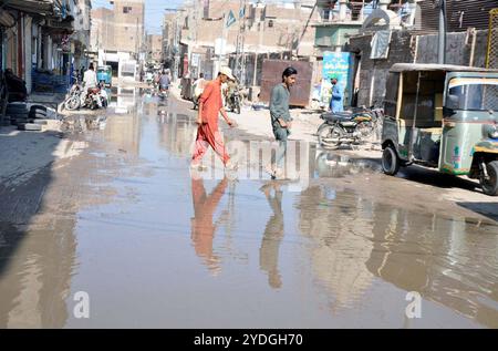 Route inondée par le débordement des eaux usées, créant des problèmes pour les résidents et les navetteurs, montrant la négligence des autorités concernées, à Hali Road à Hyderabad le samedi 26 octobre 2024. Banque D'Images