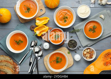Composition plate de pose avec une délicieuse soupe de citrouille sur une table en bois gris Banque D'Images