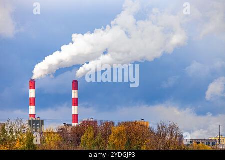 cheminée fumante de la chaufferie de la ville. fumée provenant d'une cheminée dans une zone industrielle. fumée blanche provenant des tuyaux rouges de chaudière Banque D'Images