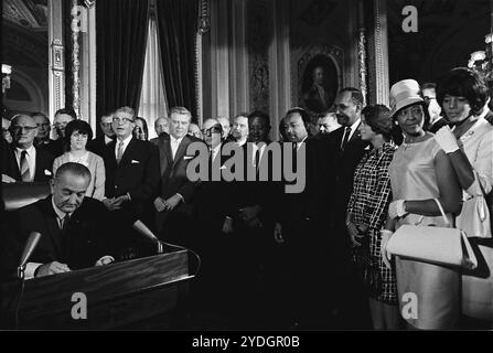 Le président Lyndon B. Johnson signe le Voting Rights Act de 1965 tandis que Martin Luther King et d'autres regardent. Banque D'Images