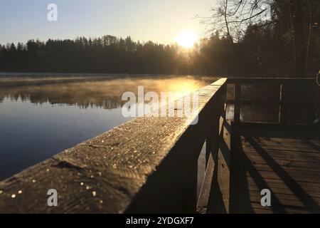 Une matinée sereine sur un pont en bois au-dessus d'un lac. Banque D'Images