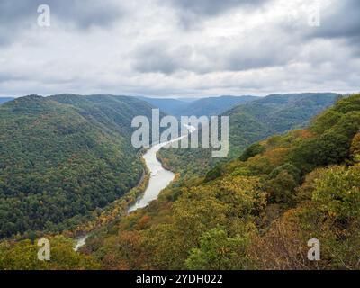 Grandview Rim au parc national de New River gorge, en Virginie occidentale, affiche des couleurs éclatantes du début de l'automne sous un ciel nuageux, créant une atmosphère captivante et d'humeur changeante Banque D'Images