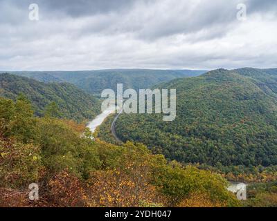 Grandview Rim au parc national de New River gorge, en Virginie occidentale, affiche des couleurs éclatantes du début de l'automne sous un ciel nuageux, créant une atmosphère captivante et d'humeur changeante Banque D'Images