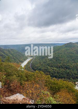 Grandview Rim au parc national de New River gorge, en Virginie occidentale, affiche des couleurs éclatantes du début de l'automne sous un ciel nuageux, créant une atmosphère captivante et d'humeur changeante Banque D'Images