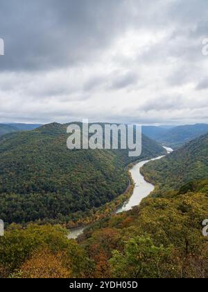 Grandview Rim au parc national de New River gorge, en Virginie occidentale, affiche des couleurs éclatantes du début de l'automne sous un ciel nuageux, créant une atmosphère captivante et d'humeur changeante Banque D'Images