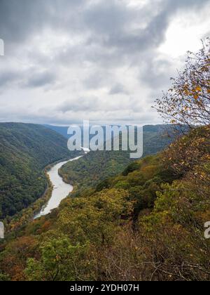 Grandview Rim au parc national de New River gorge, en Virginie occidentale, affiche des couleurs éclatantes du début de l'automne sous un ciel nuageux, créant une atmosphère captivante et d'humeur changeante Banque D'Images