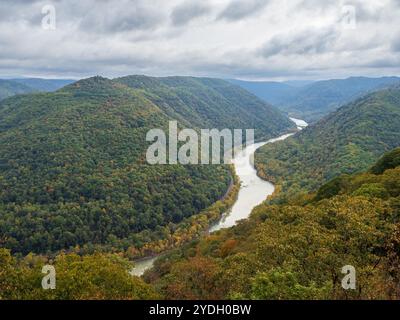 Grandview Rim au parc national de New River gorge, en Virginie occidentale, affiche des couleurs éclatantes du début de l'automne sous un ciel nuageux, créant une atmosphère captivante et d'humeur changeante Banque D'Images